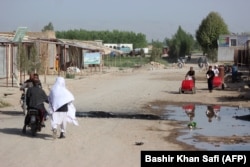 AFGHANISTAN -- Afghan residents walk near a religious school following an airstrike in the Taliban-controlled Dasht-e Archi district in Kunduz province, April 4, 2018.