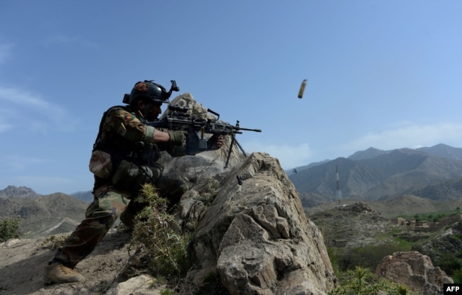 An Afghan soldier fires during an ongoing an operation against IS militants in the Achin district of Nangarhar province, April 11, 2017.