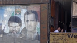 A poster bearing an image of Syrian President Bashar al-Assad (R) and Hassan Nasrallah, head of Lebanese Shi'ite movement Hezbollah, in Damascus, September 7, 2017.