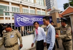 Uon Chhin and Yeang Sothearin, former journalists from the U.S.-funded Radio Free Asia (RFA), arrive at the Municipal Court of Phnom Penh on October 3, 2019. (Samrang Pring/Reuters)