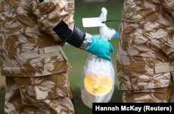 U.K. -- People in military hazardous material protective suits collect an item in Queen Elizabeth Gardens in Salisbury, Britain, July 19, 2018