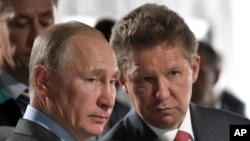 Russian President Vladimir Putin, left, and Alexei Miller, Russian natural gas giant Gazprom CEO, attend a meeting in Novobureyskiy, Russia, on Aug. 3, 2017. (Alexei Nikolsky/Pool Photo via AP)