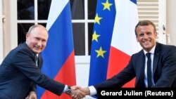 FRANCE -- French President Emmanuel Macron shakes hands with Russia's President Vladimir Putin, at his summer retreat of the Bregancon fortress on the Mediterranean coast, near the village of Bormes-les-Mimosas, August 19, 2019
