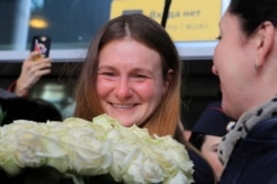 RUSSIA -- Convicted Russian agent Maria Butina, who was released from a Florida prison and then deported by U.S. immigration officials, holds flowers upon her arrival at Sheremetyevo International Airport outside Moscow, Russia Octo