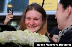 RUSSIA -- Convicted Russian agent Maria Butina, who was released from a Florida prison and then deported by U.S. immigration officials, holds flowers upon her arrival at Sheremetyevo International Airport outside Moscow, Russia Octo
