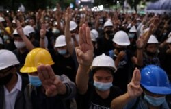Pro-democracy protesters make a three-finger salute as they march towards the Government House during an anti-government protest as they march in Bangkok, Thailand October 21, 2020. REUTERS/Athit Perawongmetha
