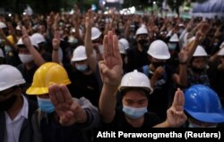 Pro-democracy protesters make a three-finger salute as they march towards the Government House during an anti-government protest as they march in Bangkok, Thailand October 21, 2020. REUTERS/Athit Perawongmetha
