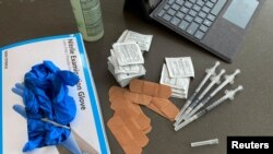 Syringes and gloves are pictured as students receive coronavirus disease (COVID-19) vaccines on the campus of the University of Memphis in Memphis, Tennessee, U.S., July 22, 2021. REUTERS/Karen Pulfer Focht/File Photo