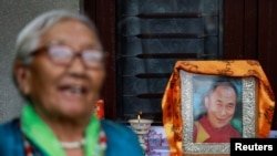 A Tibetan woman dressed in traditional attire stands near the portrait of Dalai Lama during a function organized to mark his 86th birthday celebration in Lalitpur, Nepal, on July 6, 2021. Navesh Chitrakar/Reuters 