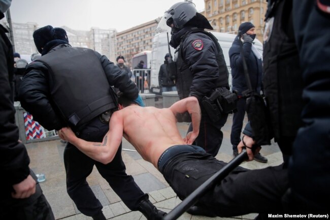 Riot police detain a protester during January 23, 2021, rally for Navalny.