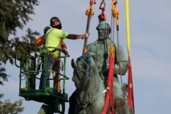 Workers remove a statue of Confederate General Robert E. Lee, after years of a legal battle over the contentious monument, in Charlottesville, Virginia, July 10, 2021. (REUTERS/Evelyn Hockstein)
