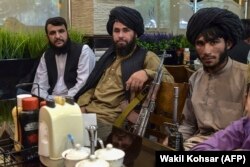 Taliban fighters wait for their meals to be served as they have lunch at a restaurant in Kabul on August 26, 2021. (Wahil Koshar/AFP)