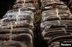 U.S. service members secure humanitarian aid, bound for airdrop over Gaza, onto a cargo aircraft at an undisclosed location within the U.S. Central Command area of responsibility, March 1, 2024. (U.S. Air Force Handout)
