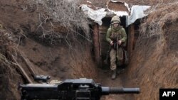 A Ukrainian serviceman walks in a trench as he stands at his post on the frontline with Russia-led separatists near the town of Zolote, in the Luhansk region, April 8, 2021.