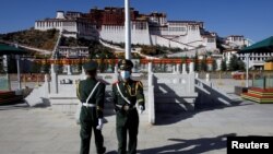 Paramilitary police officers swap positions during a change of guard in front of Potala Palace in Lhasa, during a government-organized tour of the Tibet Autonomous Region on October 15, 2020. (Thomas Peter/Reuters)