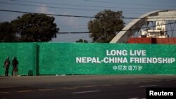 Nepalese police stand guard next to a billboard ahead of a visit by China's President Xi Jinping in Kathmandu on October 11, 2019. (Monika Deupala/Reuters)