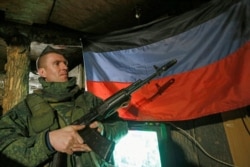 A militant of the self-proclaimed Donetsk People's Republic (DNR) holds a weapon on the line of separation from the Ukrainian armed forces south of the rebel-controlled city of Donetsk on April 2, 2021.