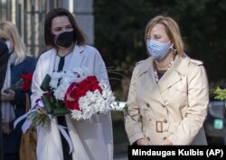 Belarusian opposition leader Svyatlana Tsikhanouskaya (left) and U.S. Ambassador to Belarus Julie Fisher take part at a ceremony to commemorate victims of the Chernobyl nuclear disaster in Vilnius, Lithuania on April 21.