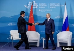 Russian President Vladimir Putin shakes hands with Li Zhanshu, Chairman of the Standing Committee of the National People's Congress of China, during a meeting on the sidelines of the 2022 Eastern Economic Forum (EEF) in Vladivostok on September 7, 2022. (Reuters)