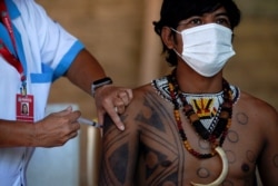 A Guarani indigenous man is inoculated with the Sinovac vaccine against COVID-19 at the Sao Mata Verde Bonita tribe camp, in the city of Marica, Brazil on January 20, 2021.