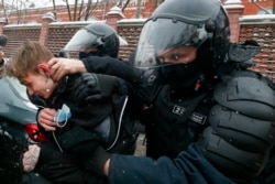 Police officers detain a young demonstrator during a protest near the Matrosskaya Tishina prison where Alexey Navalny is being held, in Moscow, Russia, on Sunday, Jan. 31, 2021.