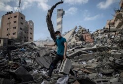 A Palestinian man inspects the damage of a six-story building which was destroyed by an early morning Israeli airstrike in Gaza City, Tuesday on Tuesday, May 18, 2021.