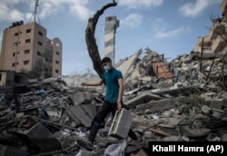 A Palestinian man inspects the damage of a six-story building which was destroyed by an early morning Israeli airstrike in Gaza City, Tuesday on Tuesday, May 18, 2021.