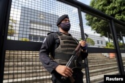 A Nicaraguan police officer keeps watch outside the Supreme Electoral Council as political parties register their presidential candidates for the November 7 general election. (Maynor Valenzuela/Reuters)
