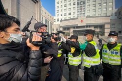 Police attempt to stop journalists from recording footage outside the Shanghai Pudong New District People's Court on December 28, 2020, where citizen journalist Zhang Zhan was sentenced over her Wuhan COVID-19 reports.