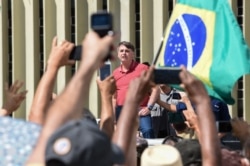 Bolsonaro speaks after joining his supporters in a motorcade to protest quarantine and social distancing measures on April 19, 2020. (AFP)