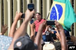 Bolsonaro speaks after joining his supporters in a motorcade to protest quarantine and social distancing measures on April 19, 2020. (AFP)