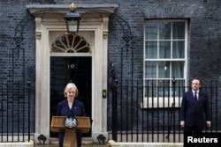British Prime Minister Liz Truss announces her resignation, as her husband Hugh O'Leary stands nearby, outside Number 10 Downing Street, London on October 20, 2022. (Henry Nicholls/Reuters)