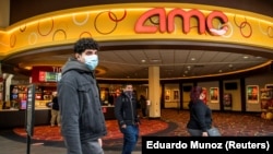 FILE PHOTO: People wear face masks as they walk by a movie theater during the coronavirus disease (COVID-19) pandemic in Newport, New Jersey, U.S., April 2, 2021.