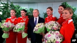 Russian President Vladimir Putin poses for a photo during his meeting with representatives of the flight crew of Russian airlines on a visit to Aeroflot Aviation School outside Moscow, Saturday, March 5, 2022. (Sputnik Kremlin Pool Photo via AP)