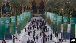 People walk through the COP28 U.N. Climate Summit, Monday, Dec. 4, 2023, in Dubai, United Arab Emirates. (AP Photo/Peter Dejong)