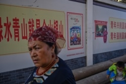 This photo taken on September 11, 2019 shows a woman walking in an ethnic Uighur neighborhood in Aksu in the region of Xinjiang. (Photo by HECTOR RETAMAL/AFP)