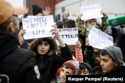 Migrants protest outside the transport and logistics center, Bruzgi, on the Belarusian-Polish border on November 25, 2021. (Kacper Pempel/Reuters)