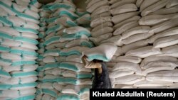A worker carries a sack of wheat flour at a World Food Program food aid distribution center in Sanaa, Yemen, February 11, 2020. (Khaled Abdullah/Reuters)