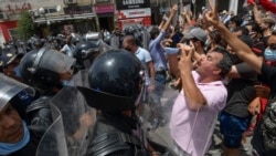 Members of Tunisian security forces face off with anti-government demonstrators during a rally in front of the parliament building in the capital Tunis on July 25, 2021.