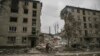 A man rides his bicycle in front of a destroyed apartment building after a Russian strike in the city of Avdiivka, Donetsk Oblast, on March 18, 2023.