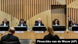 NETHERLANDS -- Presiding judge Hendrik Steenhuis, center, opens the court session for the hearing in trial of the Malaysia Airlines flight MH17 in the high-security courtroom of the Schiphol Judicial Complex, near Amsterdam, Sept. 28, 2020